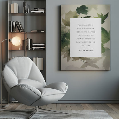 A framed art print featuring an inspirational quote by Brené Brown. The quote, 'Vulnerability is not winning or losing. It's having the courage to show up when you can't control the outcome,' is printed in black uppercase letters on a central white rectangle. The background consists of a soft watercolor illustration of green and beige leaves. The piece is enclosed in a simple black frame. Wall Art