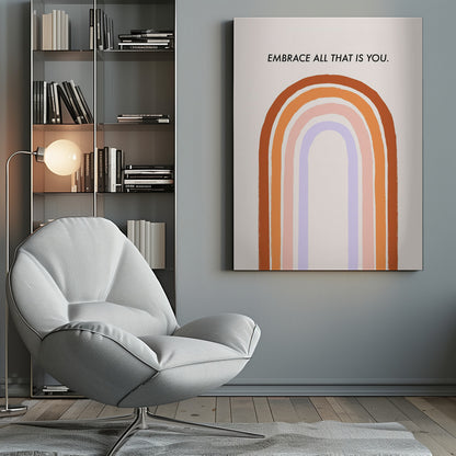 A framed art print with an inspirational quote. On a cream background, the black text reads 'EMBRACE ALL THAT IS YOU.' Below the text is a large, stylized U-shaped rainbow with thick, painted bands of terracotta, orange, pink, and lavender. Print