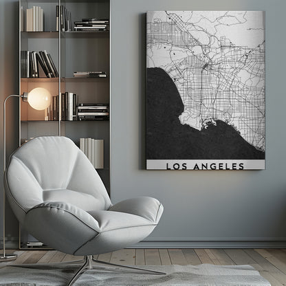 A minimalist black and white framed poster of a street map of Los Angeles. The land is white with an intricate grid of black lines representing roads and highways, while the Pacific Ocean is a solid, textured black. A white band at the bottom contains the city's name, 'LOS ANGELES', in a bold, black sans-serif font. Decor