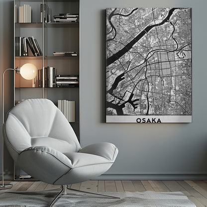 A framed black and white map of Osaka, Japan. The map details the city's streets, blocks, and rivers in a modern, graphic style. At the bottom, a white border contains the word 'OSAKA' in a bold, black, sans-serif font. Print