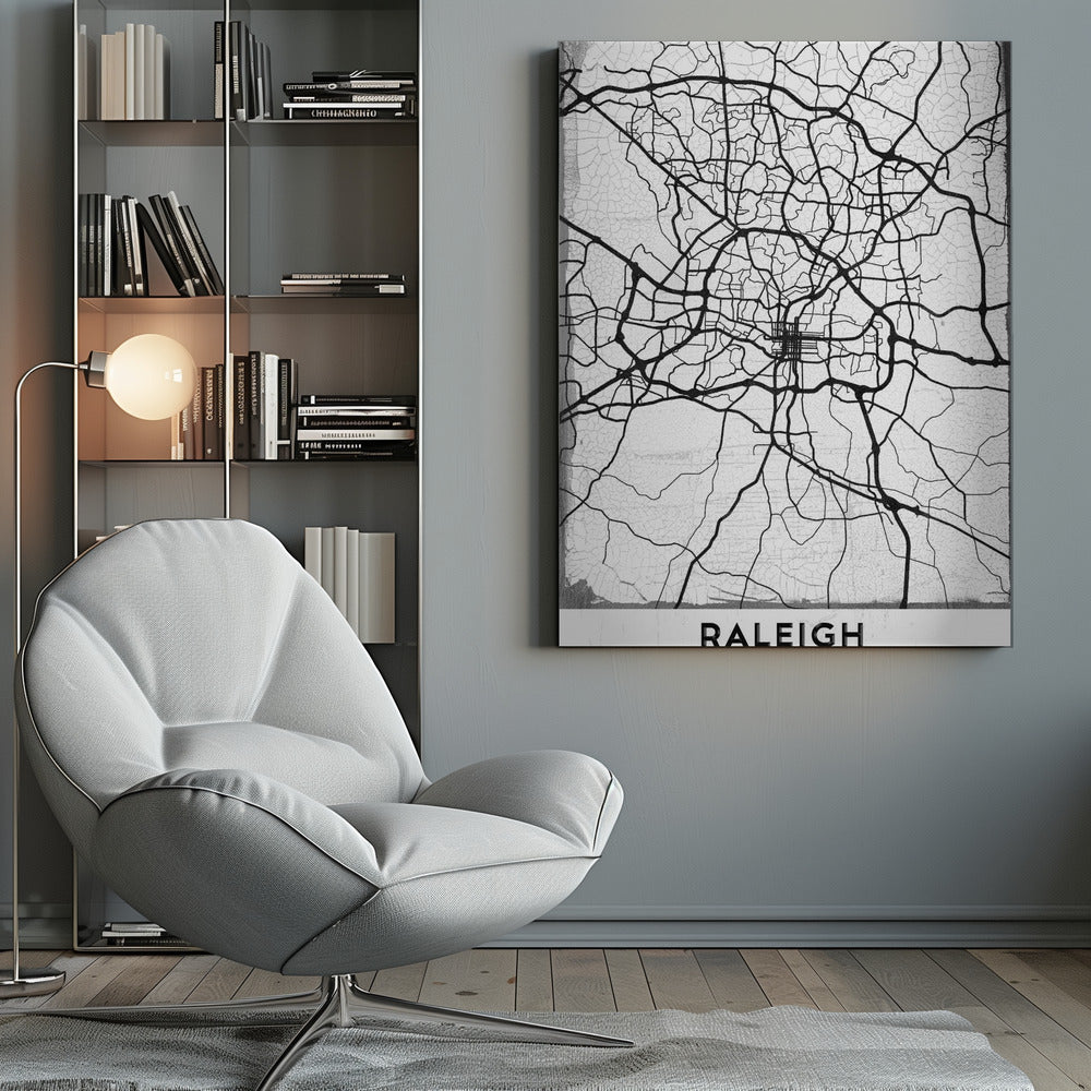 A minimalist black and white street map of Raleigh, North Carolina, displayed in a black frame. The map features black lines representing roads on a distressed, crackled white background. At the bottom, the word 'RALEIGH' is printed in a bold, black, sans-serif font. Print