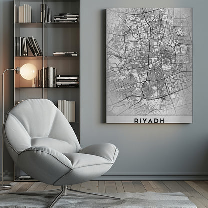 A minimalist, black and white framed poster of a city map of Riyadh. The map details the intricate network of streets and city blocks in black lines on a textured, light gray background. At the bottom, the word 'RIYADH' is printed in a bold, black, sans-serif font. Wall Art