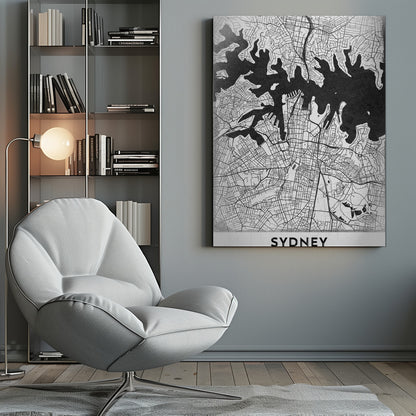 A modern black and white framed art print of a city map of Sydney, Australia. The water bodies are shown in solid textured black, while the land is depicted with a detailed white street grid. At the bottom, the word 'SYDNEY' is printed in bold capital letters. Poster