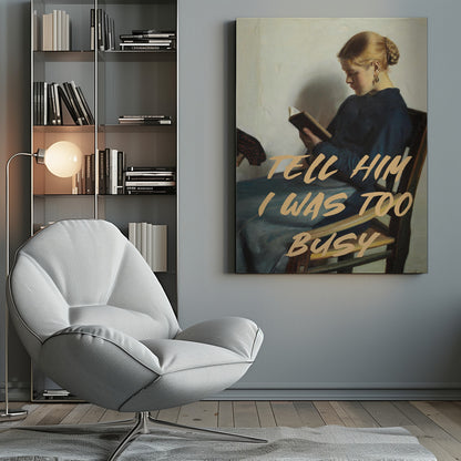A classical painting of a woman in a blue dress sitting in a wooden chair, engrossed in reading a book. Overlaid in a modern, tan-colored brush script font is the phrase 'TELL HIM I WAS TOO BUSY'. Wall Art