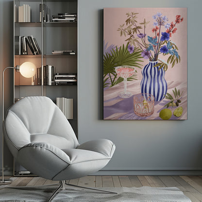 A vibrant still life painting featuring a blue and white striped wavy vase filled with a colorful bouquet of flowers. To the left is a pink cocktail in a coupe glass and a decorative tumbler. In the foreground, there are fresh limes and an olive branch. The scene is set on a draped pink cloth against a soft pink background with shadows from palm leaves. Artwork