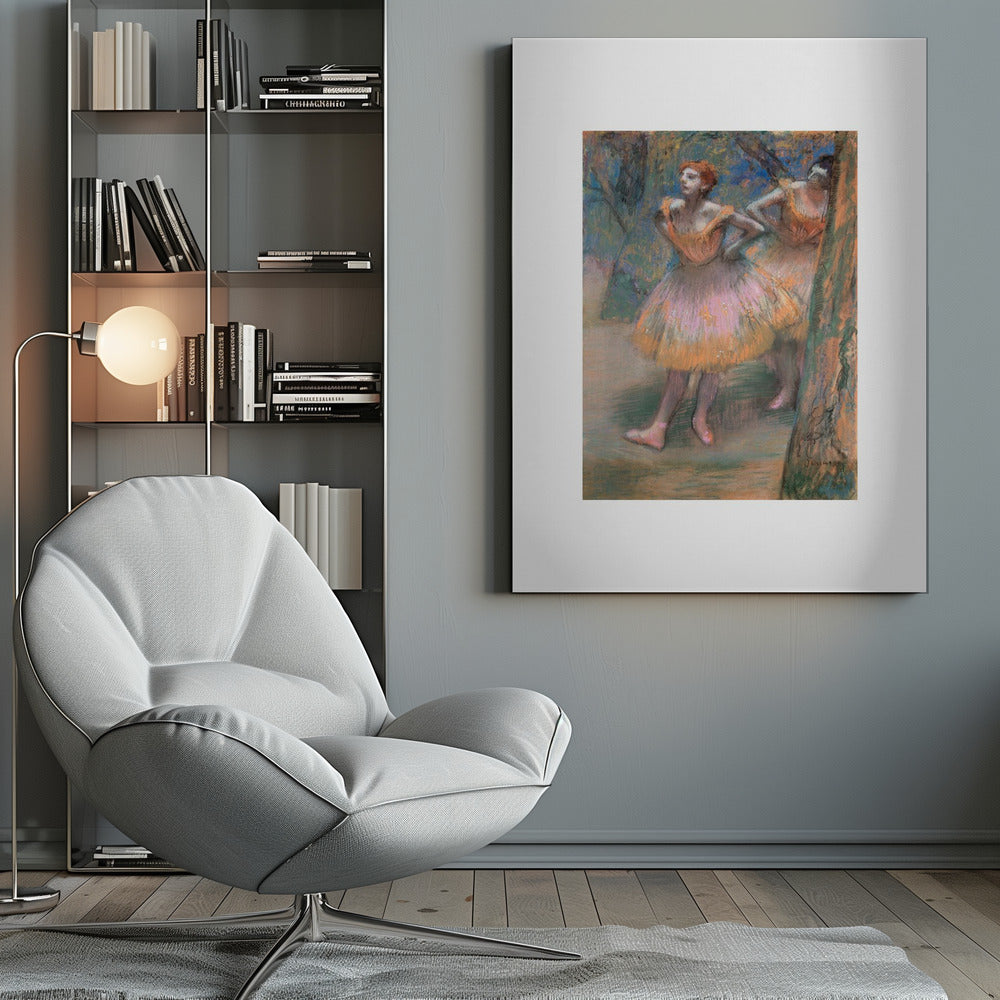 A framed vertical print of Edgar Degas's impressionist pastel drawing 'Dancers, Pink and Green'. It depicts two ballerinas in pink and orange tutus standing backstage amongst trees, captured in soft, expressive strokes. Artwork