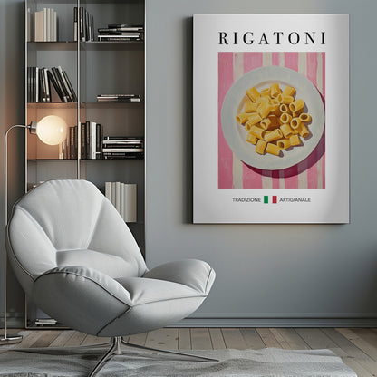 A framed art print of a vintage-style Italian food poster. It features a painting of a white plate full of uncooked rigatoni pasta on a pink and white striped background. The word 'RIGATONI' is printed in large black letters at the top, and 'TRADIZIONE ARTIGIANALE' with a small Italian flag is printed at the bottom. Artwork