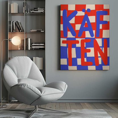 A bold graphic art print featuring the word 'KÄFTEN' split into two lines against a checkerboard background. The top line 'KÄF' is in blue text over a red and cream checker pattern. The bottom line 'TEN' is in red text over a blue and cream checker pattern. The style is playful and hand-painted, enclosed in a thin black frame. Wall Art