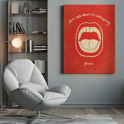 A humorous framed poster with a red background featuring a cream-colored line drawing of a large, open mouth. Above the mouth, the text reads 'don't talk when i'm interrupting' in an arch, and below it says 'please'. Print