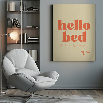 A framed art print with a cream-colored background. The words 'hello bed' are printed in a large, bold, orange serif font. Below this, in a smaller orange font, it reads '(PS: I really love you)'. In the bottom right corner, 'XOXO' is written in an orange script font. Decor