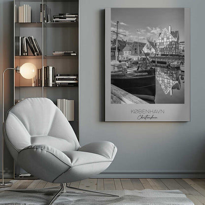 A black and white travel poster featuring a photo of Christianshavn in Copenhagen. The scene shows a boat named 'TRIPITAKA' docked in a canal, with a prominent half-timbered building across the water, its reflection visible on the surface. The bottom of the poster has text that reads 'KØBENHAVN', 'Christianshavn', and 'DANMARK'. Artwork