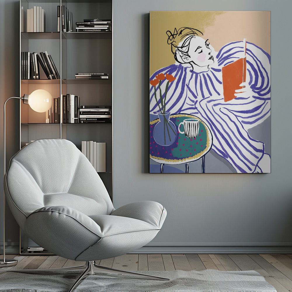 A stylized, framed illustration of a person with dark hair in a messy bun, wearing a blue and white striped top, reclining comfortably while engrossed in an orange book. Beside them is a small table with a blue vase holding three orange flowers and a black and white striped mug. The background is a soft beige color. Print