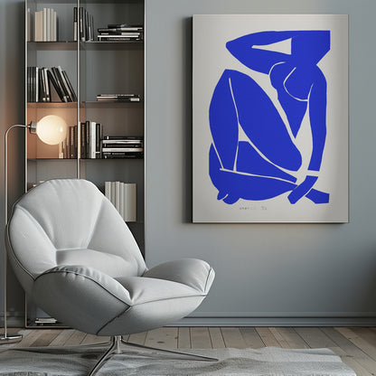 A framed print of Henri Matisse's 'Blue Nude II', featuring a bold, royal blue paper cutout of a seated female nude against an off-white background. The figure is stylized and abstract, with limbs folded and one arm behind her head. Print