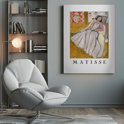 An art print poster of a Henri Matisse painting. The image features a woman with dark hair wearing a long, light-colored dress, reclining in a golden-yellow armchair. The background includes a red and white floral pattern and other decorative elements. The word 'MATISSE' is printed in large black letters below the artwork, all enclosed in a black frame. Decor