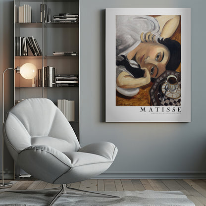A framed art print of Henri Matisse's painting, 'Lorette con una tazza di caffè' (Lorette with a Cup of Coffee). The portrait features a woman with dark hair lying down, gazing directly at the viewer, with a cup of coffee on a checkered saucer beside her. The artist's name and the title are printed below the image. Decor