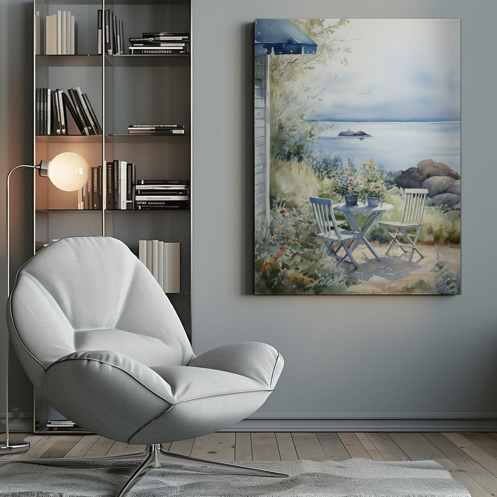 A watercolor painting of a tranquil coastal scene. A light blue bistro table and two matching chairs sit in a lush garden filled with flowers, overlooking a calm body of water. In the distance, a small island is visible under a soft, hazy sky. Part of a house with a blue awning can be seen on the left. Print