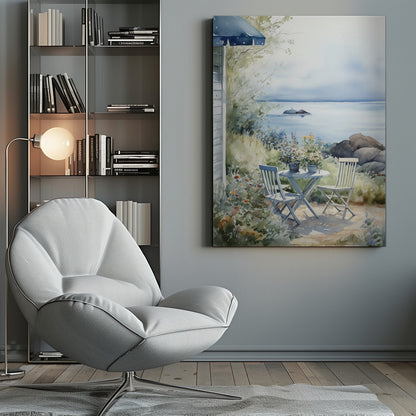 A watercolor painting of a tranquil coastal scene. A light blue bistro table and two matching chairs sit in a lush garden filled with flowers, overlooking a calm body of water. In the distance, a small island is visible under a soft, hazy sky. Part of a house with a blue awning can be seen on the left. Print