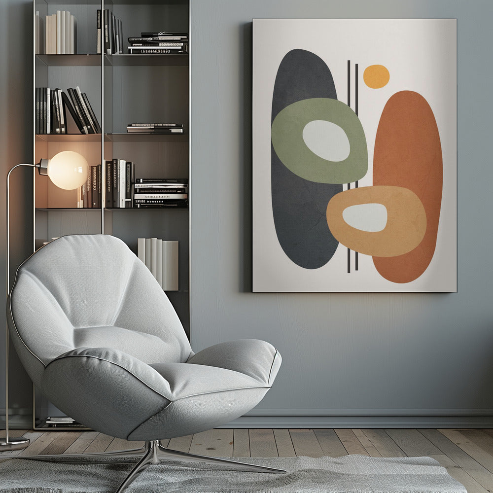 An abstract art print in a black frame, featuring a collection of overlapping organic shapes in muted earth tones. A large dark gray oval is on the left, next to a burnt orange oval on the right. In front of them are two ring-like shapes, one olive green and one light orange, both with off-white centers. A small yellow circle is near the top, and thin vertical black lines cut through the composition. The background is a soft off-white. Print