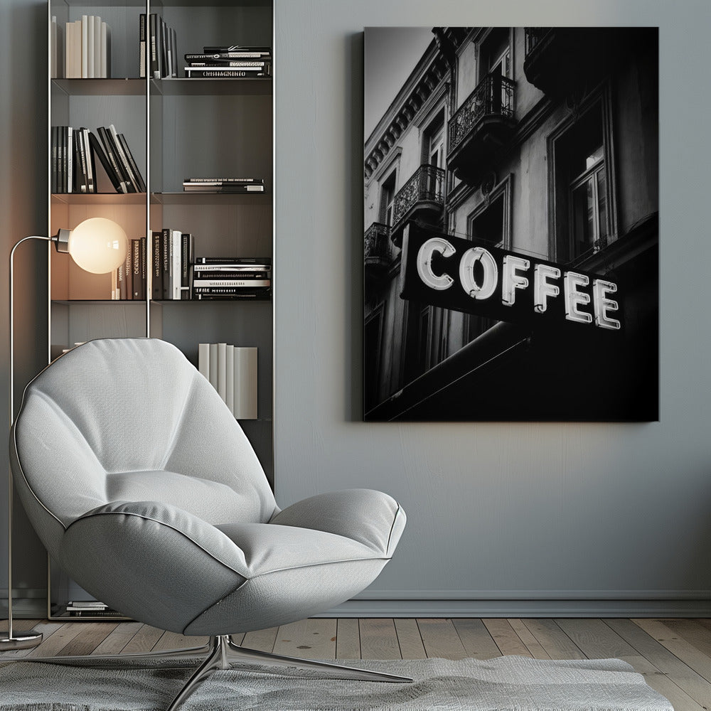 A dramatic, low-angle, black and white photograph of a bright white neon sign that reads 'COFFEE', mounted on a classic-style building with ornate balconies. Print