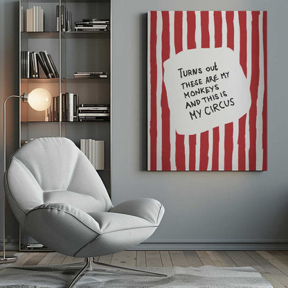 A framed art print featuring the humorous quote 'Turns out these are my monkeys and this is my circus' in black handwritten text. The text is centered on a white, cloud-like shape against a background of bold, hand-painted red and white vertical stripes, reminiscent of a circus tent. Poster
