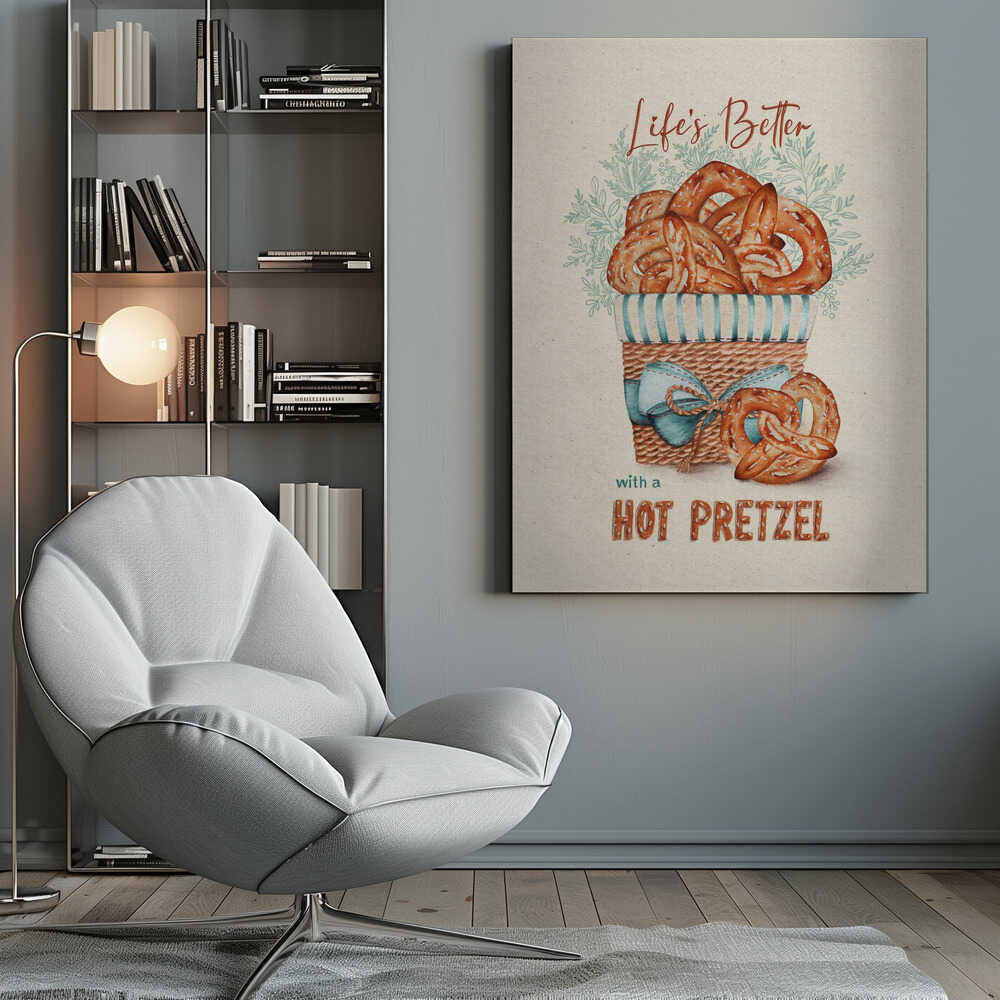 A vintage-style framed artwork featuring a watercolor illustration of a wicker basket overflowing with golden-brown pretzels. The text reads 'Life's Better with a HOT PRETZEL' in a warm brown font against a cream-colored textured background. A blue ribbon is tied around the basket, and light blue foliage is visible behind it. Poster