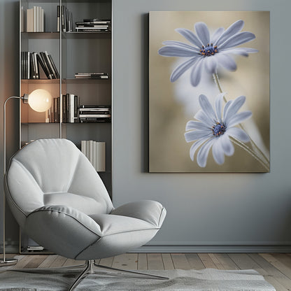 A soft-focus close-up photograph of two light blue daisies with vibrant blue and orange centers. The flowers are positioned one above the other against a warm, blurry beige background, creating a dreamy and serene atmosphere. Wall Art