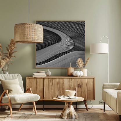 A framed black and white abstract artwork featuring a dynamic composition of flowing, wave-like forms created from dense, parallel lines. Lighter-toned curves sweep across the canvas, overlapping darker areas and creating a sense of depth, texture, and movement. Decor