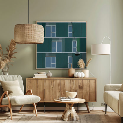 A framed photograph of a modern, dark green building facade with a grid of windows across three levels. A single industrial-style pendant lamp hangs in front of the building on the right side, interrupting the symmetrical pattern. The entire scene is enclosed by a light wood frame. Decor