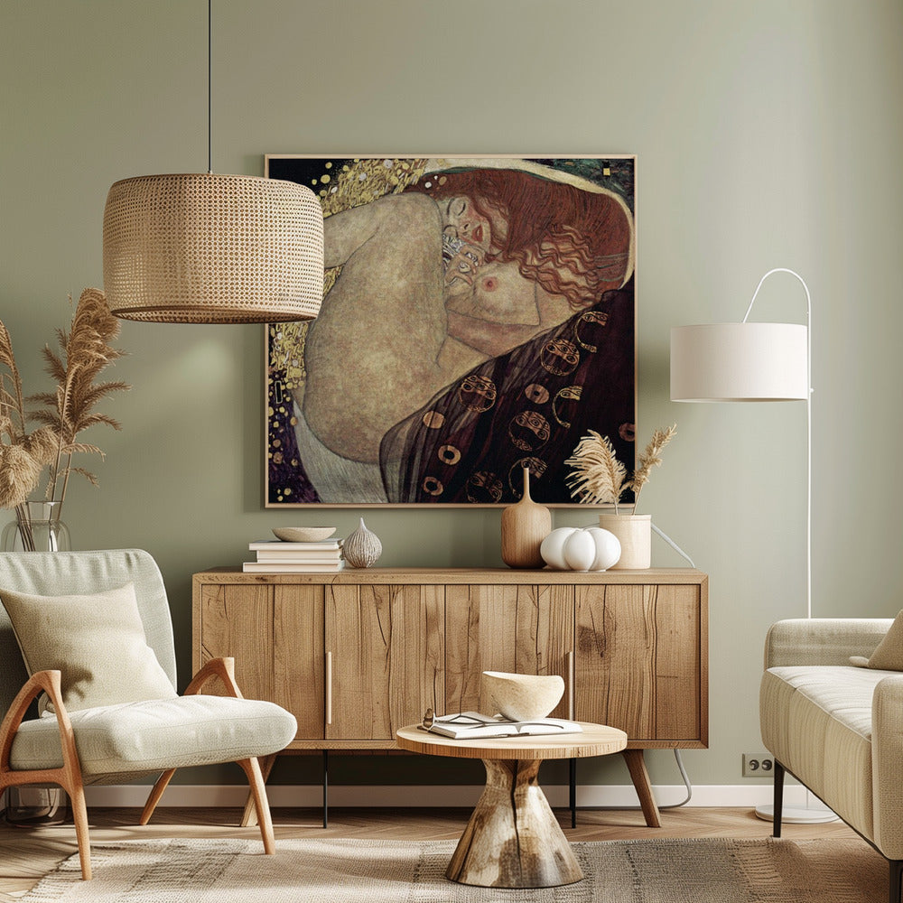 A print of Gustav Klimt's 1907 painting, 'Danaë'. The artwork depicts a sleeping, nude woman with vibrant red hair curled into a fetal position, receiving a shower of golden rain. The style is characteristic of Art Nouveau, with rich, decorative patterns on surrounding fabrics against a dark, star-like background, all within a light wood frame. Wall Art