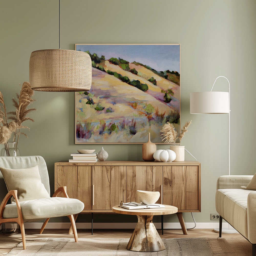 An impressionist oil painting of golden, rolling hills dotted with green shrubs under a pale blue sky, framed in light wood.