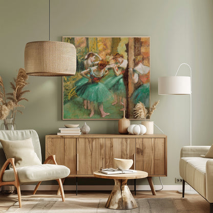 An impressionist painting of four ballet dancers in green tutus backstage. The dancers are adjusting their costumes and hair against a warm, painterly background of yellow, orange, and brown tones. The artwork is displayed in a light wood frame. Wall Art