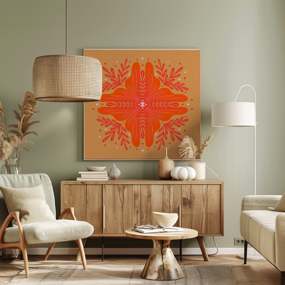 A square, framed artwork featuring a symmetrical, abstract floral design in the style of a mandala. The central element is a vibrant orange flower with intricate pink and red details, set against a warm, mustard-orange background. The design is surrounded by red leafy branches and decorative dots. Decor
