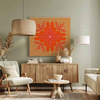 A square, framed artwork featuring a symmetrical, abstract floral design in the style of a mandala. The central element is a vibrant orange flower with intricate pink and red details, set against a warm, mustard-orange background. The design is surrounded by red leafy branches and decorative dots. Decor