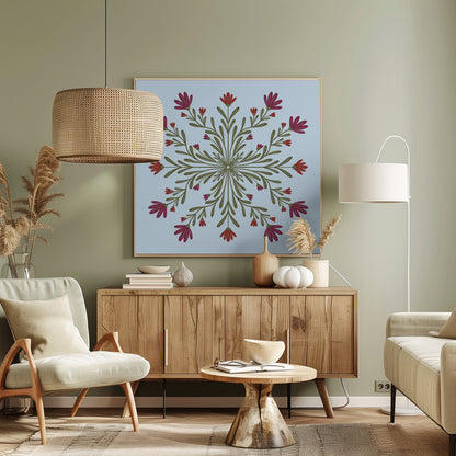 A framed art print with a symmetrical floral mandala on a light blue background. Olive green stems and leaves radiate from the center, blooming with magenta and red flowers. The artwork is enclosed in a light wood frame. Wall Art