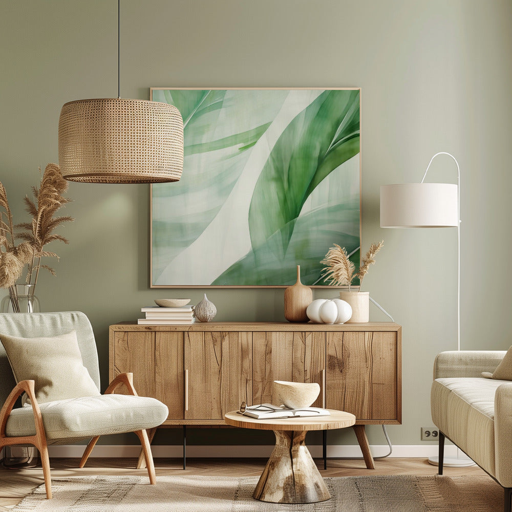 A light wood framed artwork depicting a close-up, abstract watercolor painting of large, overlapping tropical leaves. The shades of green are soft and translucent, creating a layered effect against a bright white background, evoking a sense of calm and nature. Print