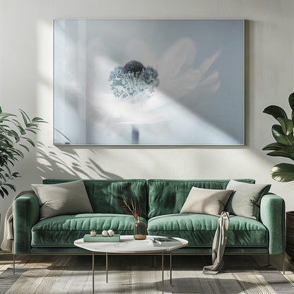 A dreamy, soft-focus macro photograph of a single white anemone flower. The flower has a dark center surrounded by delicate blue-tipped stamens. The background is a soft, pale blue, and the entire image is presented within a silver frame. Wall Art