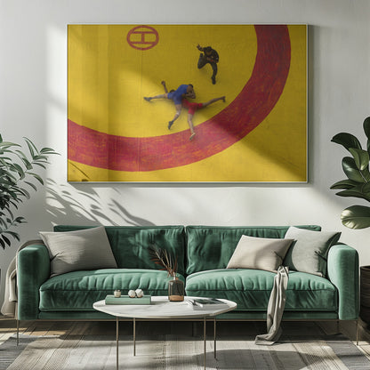 An aerial, high-angle photograph of a wrestling match in a silver frame. Two wrestlers, one in a blue singlet and the other in red, are locked in a hold on a vibrant yellow mat marked with a thick, painted red circle. A referee dressed in black stands nearby, gesturing. Artwork