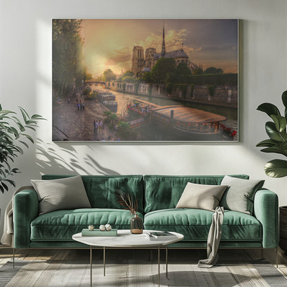 A scenic photograph of the Notre Dame Cathedral in Paris during a warm, golden sunset, as viewed from across the River Seine. People are strolling along the cobblestone riverbank and riding on tour boats docked on the water. The image is presented within a silver picture frame. Decor