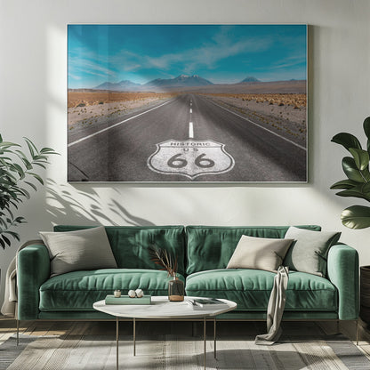 A framed photograph of the iconic Historic US Route 66 shield painted on a long, straight asphalt road that stretches through a desert landscape toward distant snow-capped mountains under a vibrant blue sky. Wall Art