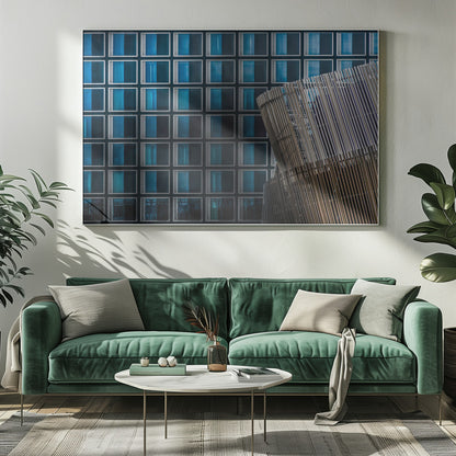 An architectural abstract photograph featuring a modern building facade with a grid of blue and black square windows, contrasted by a curved, slatted structure in the foreground, all enclosed in a silver frame. Wall Art