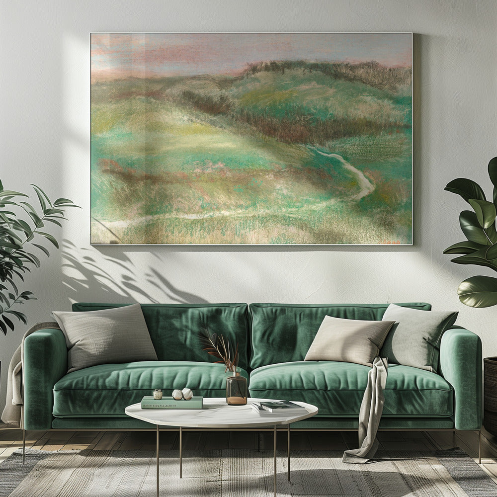 A framed, impressionistic pastel drawing of a rolling green landscape with a winding path or stream. The hills are a mix of vibrant and muted greens with earthy brown tones, under a soft pink and pale blue sky. The texture is soft and painterly, and the artwork is enclosed in a simple silver frame. Artwork