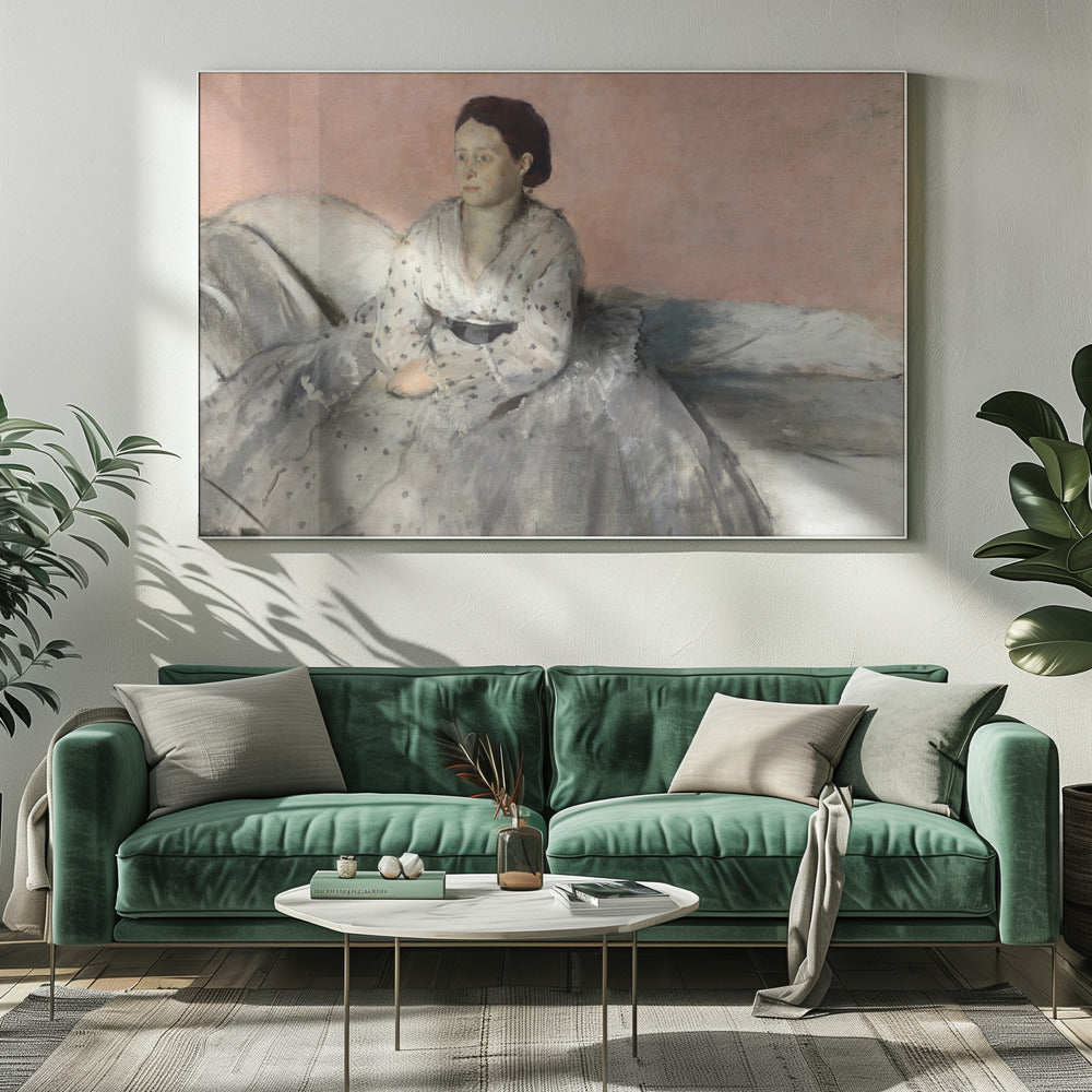 A framed impressionist painting titled 'Mélancolie' by Edgar Degas, depicting a woman with dark hair pulled back, seated on a couch or bed. She wears a white and grey polka-dotted dress with a black sash and has a pensive expression, looking off to the side against a soft pink background. Decor