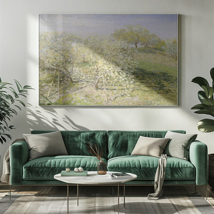 An impressionist painting of an orchard in full bloom, with white and yellow blossoms covering the trees. The orchard is set on a rolling green hillside under a pale, hazy sky, with soft shadows cast on the grass. The artwork is presented in a silver frame. Wall Art