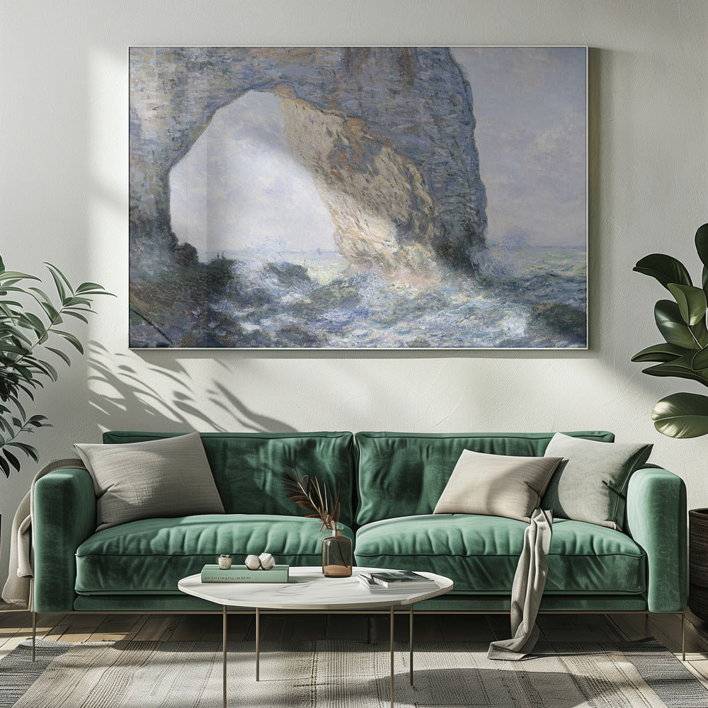 An impressionist painting by Claude Monet of the Manneporte rock arch at Étretat, France. Sunlight illuminates the massive stone arch as turbulent blue and white waves crash against the rocky shoreline below. The artwork is displayed in a silver frame. Decor