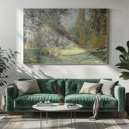 An impressionist painting by Claude Monet titled 'The Parc Monceau' displayed in a silver frame. The scene depicts a sunlit park with lush green grass, a large pink-flowering bush, and tall, leafy trees under a pale blue sky. Decor
