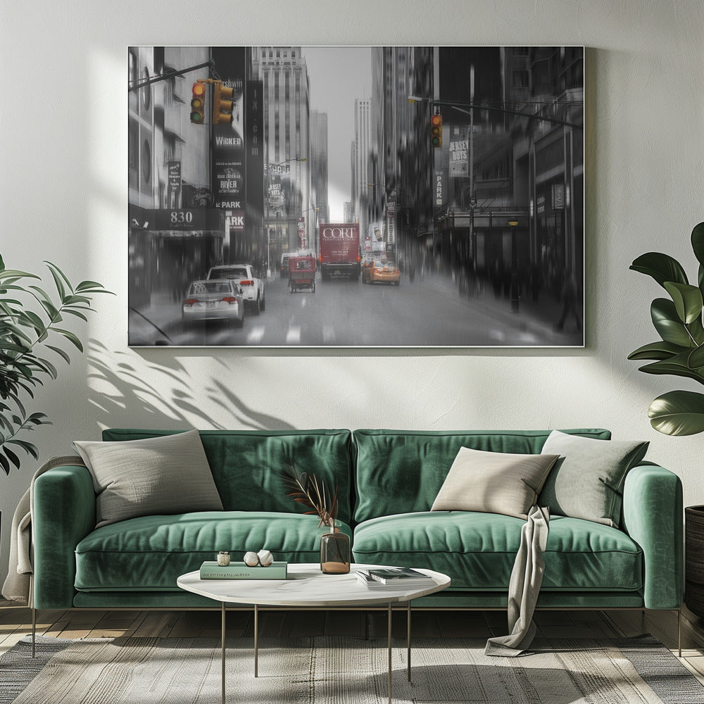A framed, stylized photograph of a busy New York City street, presented mostly in black and white with a motion blur effect. Pops of color highlight red vehicles and yellow traffic lights, drawing focus down the urban canyon lined with skyscrapers and Broadway signs. Decor