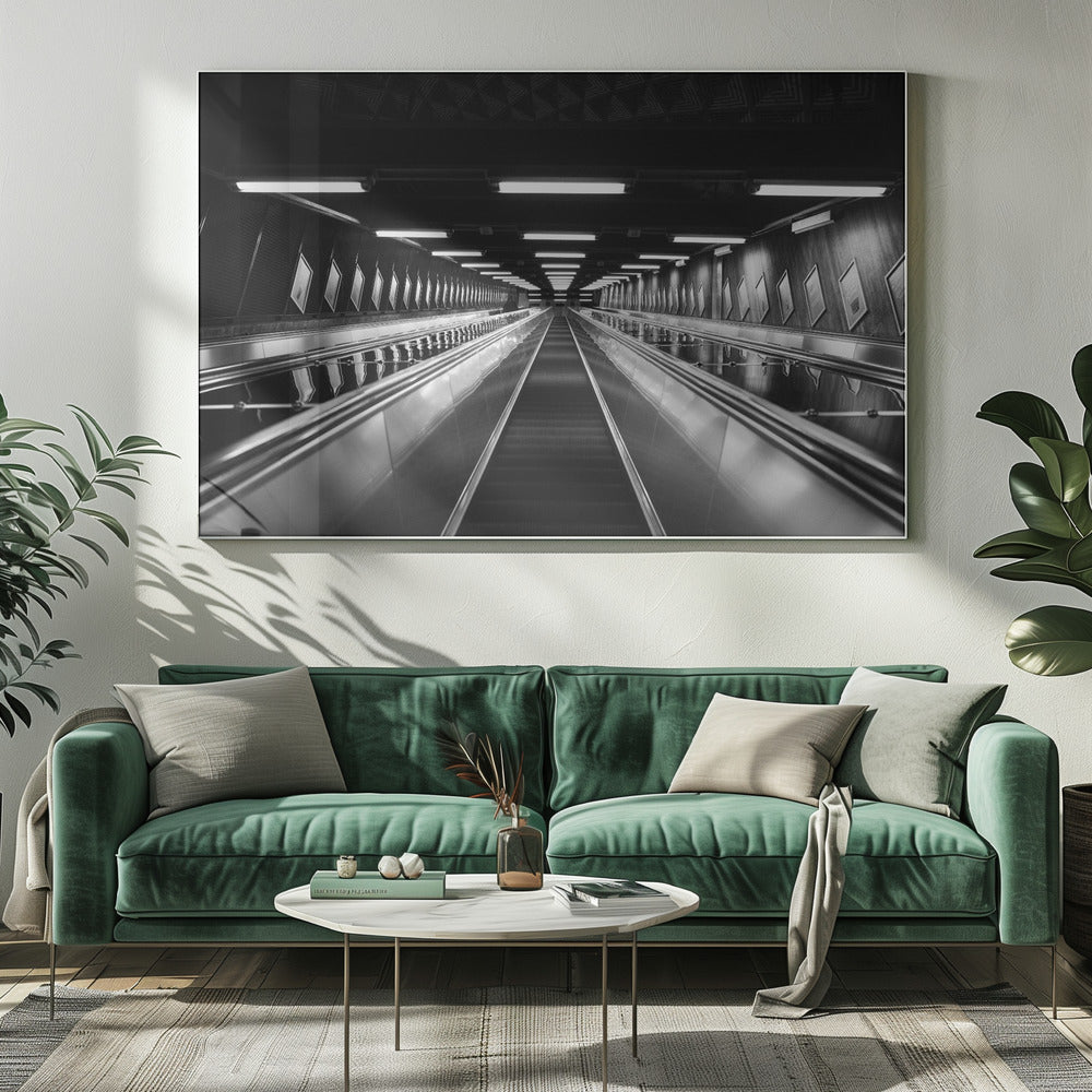 A framed, black and white, low-angle photograph looking up a long, steep, and empty escalator in a subway tunnel. The symmetrical composition uses the shiny metal handrails and rows of overhead lights as leading lines, creating a dramatic sense of depth and perspective. Print