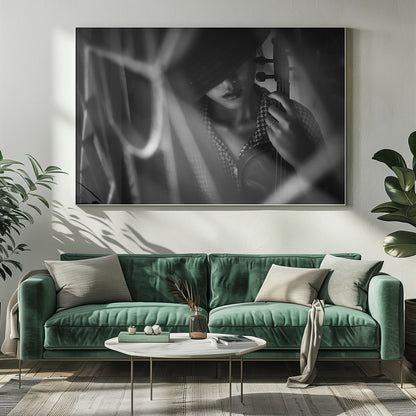 A moody, artistic black and white photograph of a woman holding a violin. Her face is partially obscured by a dark hat, creating a mysterious atmosphere. The image is shot through a blurred foreground, adding depth and intimacy to the portrait. Poster