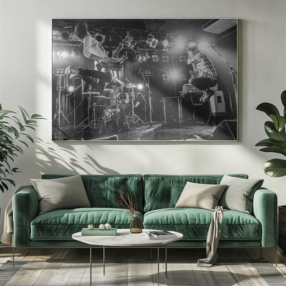 A high-energy, black and white photograph of a rock band performing live. The bassist and guitarist are frozen in mid-air as they jump, while the drummer plays in the background, all under bright stage lights. Print