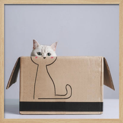 A cute white cat with green eyes peeks out of a cardboard box. The front of the box has a simple black line drawing of a cat's body, making it look as if the real cat's head belongs to the drawing. The image is set against a light gray background and enclosed in a light wood frame. Wall Art